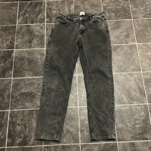 Grunt jeans - Säljer ett par mörkgrå jeansbyxor från Grunt i modellen Street Loose. Byxorna har fem fickor, raka ben och klassisk jeanslook. Tillverkade i ekologiskt material och passar perfekt till en avslappnad stil.