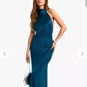 Blå/grön  satin långklänning från Boohoo - Säljer en elegant blå/grön balklänning i satin från Boohoo. Klänningen har halterneck, öppen rygg och figurnära passform. Perfekt för bal eller festliga tillfällen!🥰🥰köpt för 700 och inte använd nån gång bara testad!