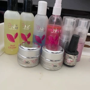 Nagelkit med geléer och rengöring från NG - Säljer ett nagelkit från NG med flera produkter: nagelrengöring, geléer i rosa och ljusrosa, glitter, och pensel. Perfekt för att skapa snygga naglar hemma. Flera burkar och flaskor i olika storlekar, samt glitter i silver och rosa. pris kan diskuteras
