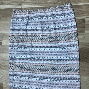 Mönstrad kjol med elastisk midja - Säljer en mönstrad kjol i vitt, grått och beige med elastisk midja. Kjolen har ett diskret geometriskt mönster och är figurnära med rak passform. Perfekt för dig som gillar en enkel men ändå unik stil.