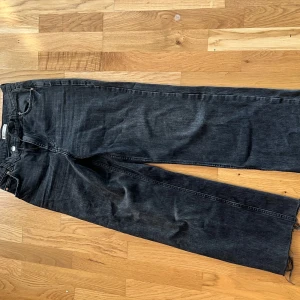 Svarta wide leg jeans från ginatricot - Säljer ett par svarta jeans med wide leg-modell från ginatricot . Jeansen har råa kanter nertill och klassisk femficksdesign. 