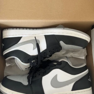 Nike Air Jordans Low svart och grå - Säljer dessa fräscha skor, perfekta nu till sommaren! Fick de i present men var tyvärr för små använda 2-3 gånger,  bara samlat på damm annars. Storlek 42 och originalbox medföljer. Pris kan diskuteras,  först till kvarn! 