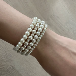 Pärlarmband i vitt, 4-pack - Fyra elastiska armband med vita pärlor i olika storlekar. Perfekt att bära tillsammans för en stilren och klassisk look. Passar både till enkel och mer uppklädd stil. Säljs som set om fyra.