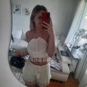 2 delat set från Fashion Nova - Säljer ett virkat 2 delat set från Fashion Nova med knyt i midjan och fransar längst ner. De är höga i midjan och har en mjuk, luftig känsla – perfekta för sommaren. Storlek S och aldrig använda, endast testad.