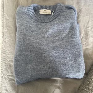 Ljusblå stickad tröja från H&M - Ljusblå stickad tröja från H&M med rund halsringning och ribbade muddar vid ärmslut och nederkant. Perfekt för kyligare dagar och enkel att matcha med olika outfits. Storlek: 146/152 men passar mig som är 165/48kg! Tar byten! Kontakta vid frågor!