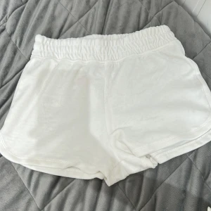 Vita shorts från Primark - Mjuka och bekväma vita shorts från Primark med elastisk midja. Perfekta för varma dagar eller som mysplagg hemma. Tillverkade i bomullsmaterial för en skön känsla.