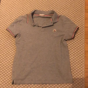 Moncler pikè - En fräsch moncler pike i storlek M. Fin grå färg som passar perfekt nu till sommaren och sllt festande
