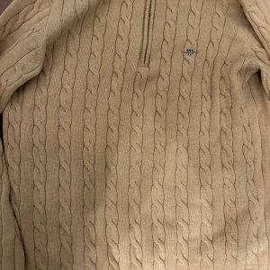 Beige halvzip-tröja från GANT - säljer en stilren Beige tröja från GANT med dragkedja vid halsen. Tröjan har långs ärmar och ett diskret broderi märke på bröstet. tveka inte att fråga. skick 10/10 storlek M