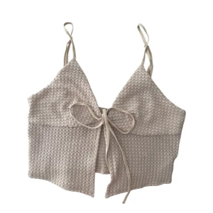 Beige croppad topp - Beige topp med smala axelband och snören framtill. Toppen är croppad och tunn, supersöt och i bra skick ☀️Skön och sitter som en smäck 🙌🏼 