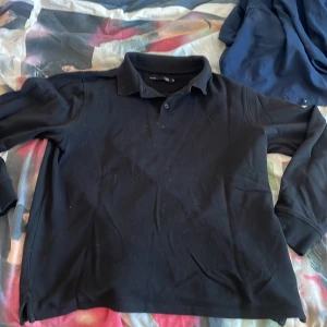 Svart pikétröja med lång ärm - Svart långärmad pikétröja perfekt för sommaren!