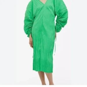 Gathered crinkled dress, grön klänning  - Gathered crinkled dress från H&M med v-ringning både fram och bak. Creppad struktur. Smickrande passform och voluminösa långärmar med snörningsdetaljer. Så snygg, men lite för stor över axlarna för mig som är S-M. 