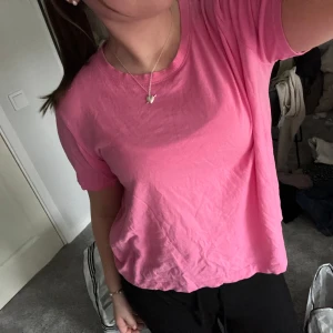 Rosa t-shirt från Zara - Enkel och snygg rosa t-shirt från Zara med rund halsringning och korta ärmar. Modellen är normal i passformen och passar perfekt till vardagslooken. Tillverkad i mjuk bomull för en skön känsla.