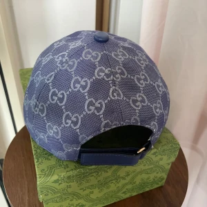 Blå keps  med monogram - Säljer en blå keps med klassiskt GG-monogram i ljusare blått. Kepsen har böjd skärm, justerbart spänne bak och är tillverkad i ett tåligt tygmaterial. Perfekt för dig som gillar exklusiva accessoarer och vill sticka ut.