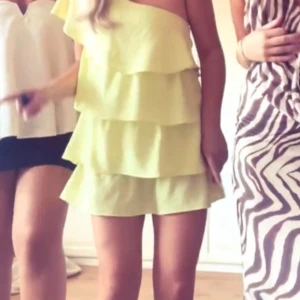 Gul volangklänning med oneshoulder - Säljer denna populära Zara klänning i storlek M,