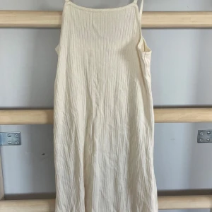 Ljus ribbad klänning från Zara - Säljer en ljus ribbad klänning från Zara med smala axelband. Klänningen har en enkel och stilren design, perfekt för varma dagar. Materialet är mjukt och följsamt.