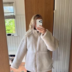 Vit teddyjacka med dragkedja - vit/beige teddyjacka ifrån carin wester använd 3 gånger och är som i nyskick. jackan har två stora fickor och spännen så du kan dra åt nere vid jackan. 