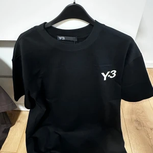 Svart / brun t-shirt  - Säljer en stilren svart och brun t-shirt med vit logga på bröstet. Klassisk passform och rund halsringning. Perfekt till streetwear eller en enkel vardagslook. 1500kr styck