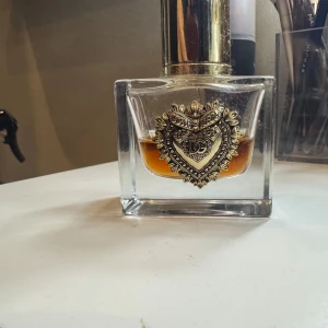 D&g devotion - Säljer parfymer jag ej använder, köpt i höstas. Ca 45% kvar se bild. Köpt för 995:- på kicks.  Dolce&Gabbana Devotion Eau de Parfum-doften är en sensorisk resa – förförisk och lugnande – som är kapabel att framkalla den positivitet som Dolce&Gabbana värdesätter, vilket symboliseras av det ikoniska Sacred Heart-emblemet. En doftskapelse av utsökta kontraster, ljusa toppnoter och sensuella basnoter. DESIGNEN Sacred Heart-emblemet, med sina distinkta mönster, pryder Devotion Eau de Parfum-flaskan. 
