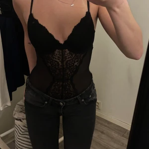 Svart spetsig bodysuit med tunna axelband - Säljer en svart body från hm som har lite spetsdetalj framtill och baktill. Klippt bort lappen men tror storleken är 75A/75B passar mig perfekt som brukar skifta mellan dom två storlekarna 💕