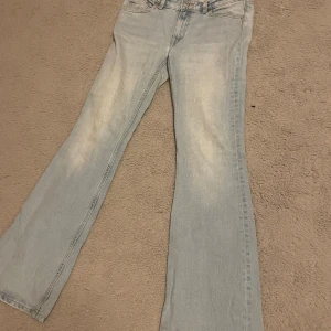 Ljusblå bootcut jeans - Säljer ett par ljusblå bootcut jeans. Jeansen har en lätt tvättad look och sitter tajt upptill med utsvängda ben. Perfekta för dig som gillar stockholmstil och vill ha ett par snygga jeans till vardags.