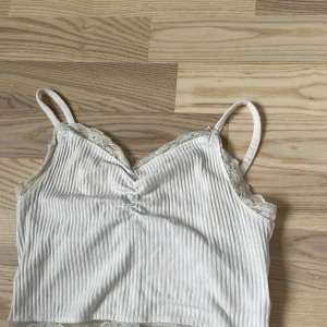 Spetslinne - Supersöt vit ribbad linnetopp från FB Sister med tunna axelband och spetsdetaljer. 