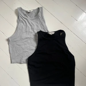 Två baslinnen i svart och grå - Säljer två enkla och stilrena linnen i svart och ljusgrå färg. Båda har ärmlös design och rund halsringning, perfekta att matcha till jeans eller kjol. Mjukt bomullsmaterial som är skönt mot huden. Skriv för fler bilder💞