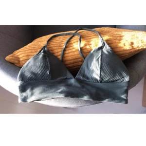 Bikinitopp - Grön bikinitopp från Stadium i strl. 34. Defekt på sista bilden där jag försökt sy ihop toppen då den sprätte upp.