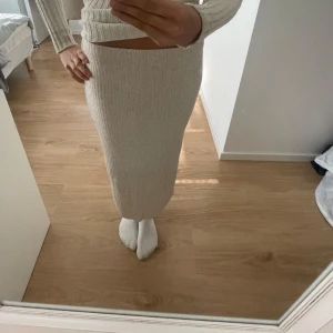 Beige ribbad långkjol - 💖storlek M men skulle snarare säga S💖Säljer en beige ribbad långkjol med tight passform. 🥰Kjolen är stickad och har en mjuk, stretchig känsla som sitter snyggt på kroppen.💖lite för kort för mig som är ca 170🥰