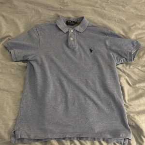 Ljusblå pikétröja från Polo Ralph Lauren - Denna har använts endast en gång så iprincip helt ny. Classic fit storlek s. Jag skulle säga att den eventuellt kan passa folk som bär s.