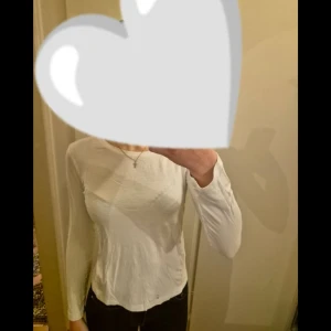 Vit långärmad tröja  - Säljer en enkel och stilren vit långärmad tröja i mjukt material. Modellen är tight och passar perfekt till nästan allt. Klassisk rund halsringning. Bild 5 kan man se att under armhålan håller sömmen på att gå sönder lite, men det går att fixa lätt. 