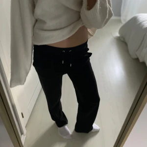 Svarta mjukisbyxor från Juicy Couture - Svarta mjukisbyxor från Juicy Couture med dragsko i midjan och raka ben. Byxorna har fickor framtill och är tillverkade i ett mjukt material som känns skönt mot huden. Perfekta för en snygg men avslapnad outfit. (Använda max 5-8 gånger) fortfarande jättebra skick, och fräscha. 