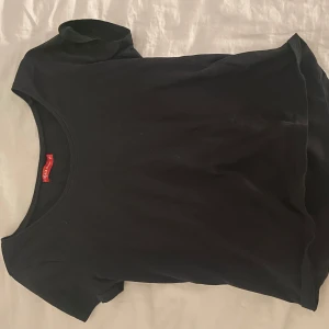 Svart t-shirt - En basic svart t-shirt med rund halsringning och korta ärmar. Perfekt att matcha med jeans eller kjol för en enkel och stilren look.