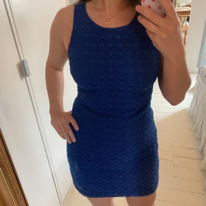 Blå spetsklänning från Zara - Säljer en blå, ärmlös klänning från Zara med vackert spetsmönster. Klänningen är figurnära och har rund halsringning. Perfekt för en romantisk feminin look.