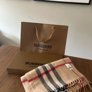 Burberry Halsduk - Säljer en klassisk beige halsduk från Burberry i 100% kashmir | Skick: 10/10 | Alla original tillbehör medföljer | Hör av er vid minsta fundering! 📩