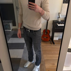 Mörkgrå  jeans  - Säljer ett par mörkgrå jeans från Jack & Jones med skor snygg tvätt. Jeansen har slim passform och midwaist, perfekta till vardags. Snygga detaljer med kontrastsömmar och bälteshällor. Storlek är 31w 32L. Köptes för 1200kr och knappt använda. 