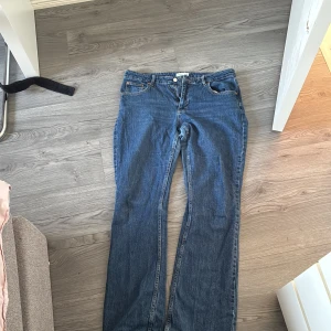 Blå bootcut jeans från Perfect Jeans - Säljer ett par klassiska blå bootcut jeans från Perfect Jeans. Jeansen har fem fickor, knapp och dragkedja framtill samt kontrastsömmar. Perfekta för dig som gillar en tidlös jeanslook med lite utsvängda ben.