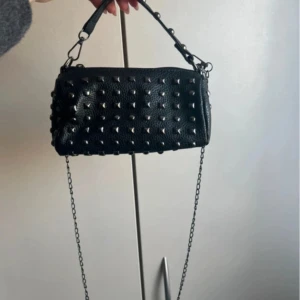 Svart väska med nitar - Snygg väska med silvriga nitar. Finns både kort och långt band. Inga defekter.
