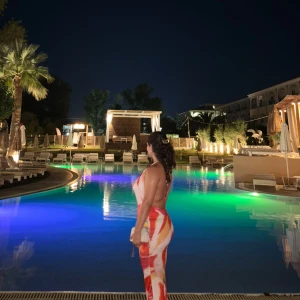 Färgglad halterneckklänning med mönster - Säljer en snygg och färgstark halterneckklänning med mönster i rosa, orange, rött och vitt. Klänningen har djup v-ringning och är ärmlös med öppen rygg. Perfekt för sommarens alla tillfällen!