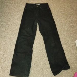 Svarta byxor från Madlady - Svarta byxor från Madlady med klassisk femficksdesign och raka, vida ben. Byxorna har normal passform och stängs med knapp och dragkedja. Perfekta för dig som gillar en enkel och stilren look.