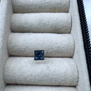 Silverfärgat örhänge med blå sten - Säljer ett stilrent örhänge i silverfärg med en fyrkantig blå sten. Perfekt för dig som gillar minimalistiska smycken med en touch av färg. Passar till många olika looks och är lätt att matcha med andra accessoarer.