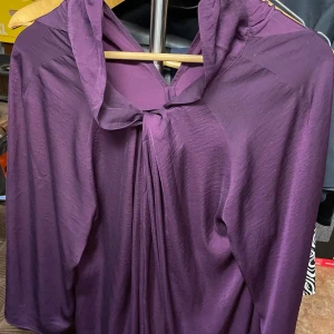 Inwear lila långklänning med draperad krage stl 40 - Säljer en elegant lila långklänning med draperad krage och trekvartsärm. Klänningen har en lös passform och ett mjukt, lätt material som faller snyggt. Perfekt för dig som vill ha en stilren och bekväm look.