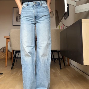 Ljusblå raka jeans från Monki - Säljer ett par ljusblå jeans från Monki med rak passform. Jeansen har hög midja och är tillverkade i denim med snygg tvätt. Perfekta för en avslappnad och trendig look. Jag är 160 brukar bära Xs/34