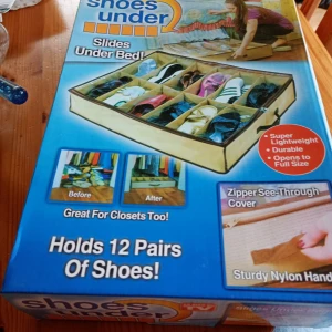 Beige förvaringsväska Shoes Under - Praktisk beige förvaringsväska från Shoes Under som rymmer 12 par skor. Väskan har genomskinligt lock med dragkedja och är tillverkad i lätt och slitstark nylon. Perfekt att skjuta in under sängen eller ha i garderoben för att hålla ordning på skorna. 15 cm hög.