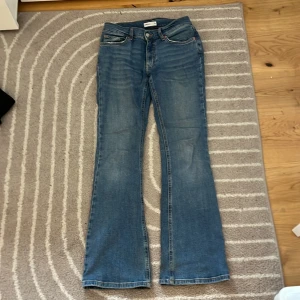Blå bootcut jeans från Gina tricot  - Snygga blå bootcut jeans från Gina tricot. Jeansen har normal midja, lätt slitna detaljer vid fickor och benslut.🌸
