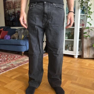 Weekday Galaxy svarta jeans 33/32 - Säljer ett par svarta Weekday Galaxy jeans i rak modell. Jeansen har klassisk femficksdesign, normal passform och är tillverkade i bomull. Snygg mörk tvätt som passar till allt och skön midja. Perfekta för dig som gillar en clean och enkel look.