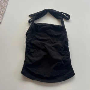 Svart topp - Svart topp som man knyter i nacken. Använd 1 gång. Kolla gärna in mina andra annonser och köp gärna bundle då får du extra rabatt!