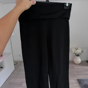 Svarta yogapants från Bik Bok - Svarta yogapants från Bik Bok med hög midja och stretchig passform. Tillverkade i mjukt material av 93% bomull och 7% elastan, vilket gör dem riktigt bekväma och följsamma. Perfekta för en chill vardagslook eller när du vill ha något enkelt och stilrent. Önskar du veta exakta mått? Tveka inte att höra av dig!