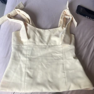 Ljusgul linnetopp med knytband - Den populära toppen från Zara. Har defekter, lite fläckar utanpå och inuti som syns!Säljer billigt därför😊linnet är ändå i bra skick men har fläckar.  Fråga absolut om mer bilder