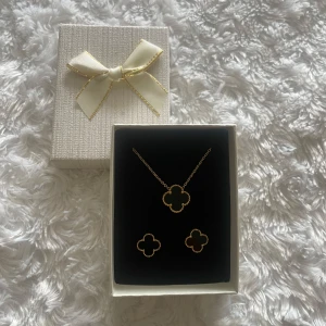 Guldigt halsband & örhängen fyrklöver - Superfint smyckeset innehållande ett halsband och örhängen i guld och svart färg. Helt nytt och oanvänt. Säljs i en gullig presentask. 🌸💕