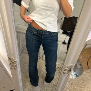 Blå bootcut jeans från Zara, stl 34 - Säljer ett par klassiska blå jeans från Zara i storlek 34. Modellen har bootcut-ben, låg midja och råa, fransiga benslut för en cool vibe. Jeansen är i stretchig bomull och sitter snyggt över höften. Perfekta till sneakers eller boots.